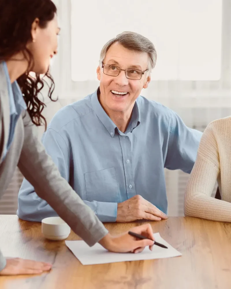 Insurance Concept. Happy senior couple consulting with female agent at office, signing papers